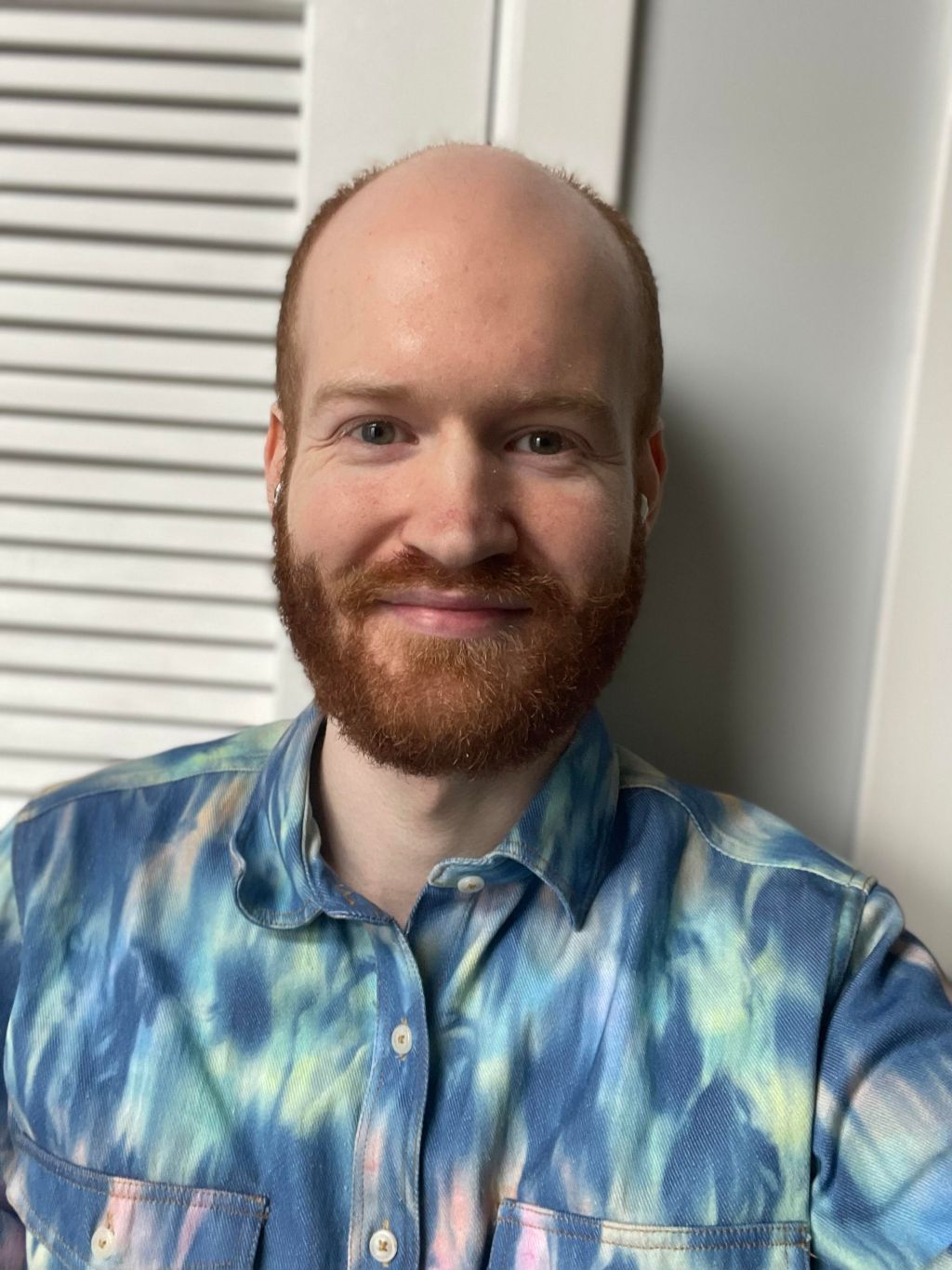 Headshot of Mark in an aurora borealis-print shirt